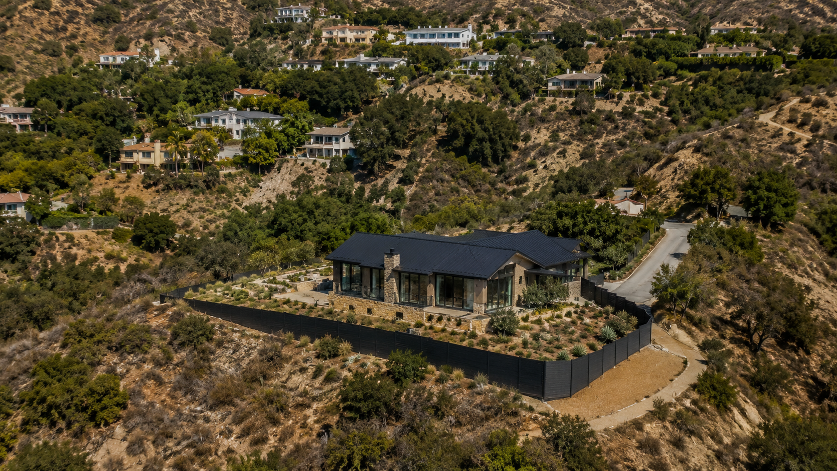 Aerial view of a Los Angeles hillside property with a continuous fire-resistant fence